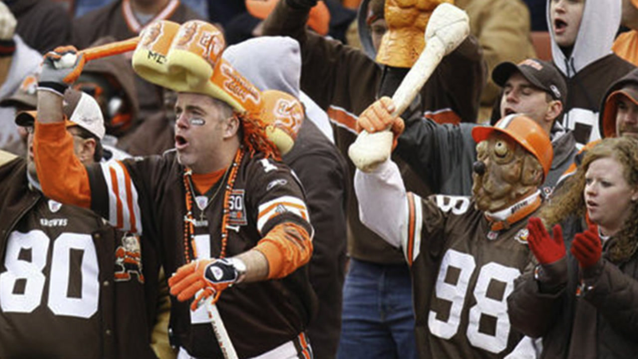 Browns fans in the Dawg Pound with a dog mask, a bone and face paint