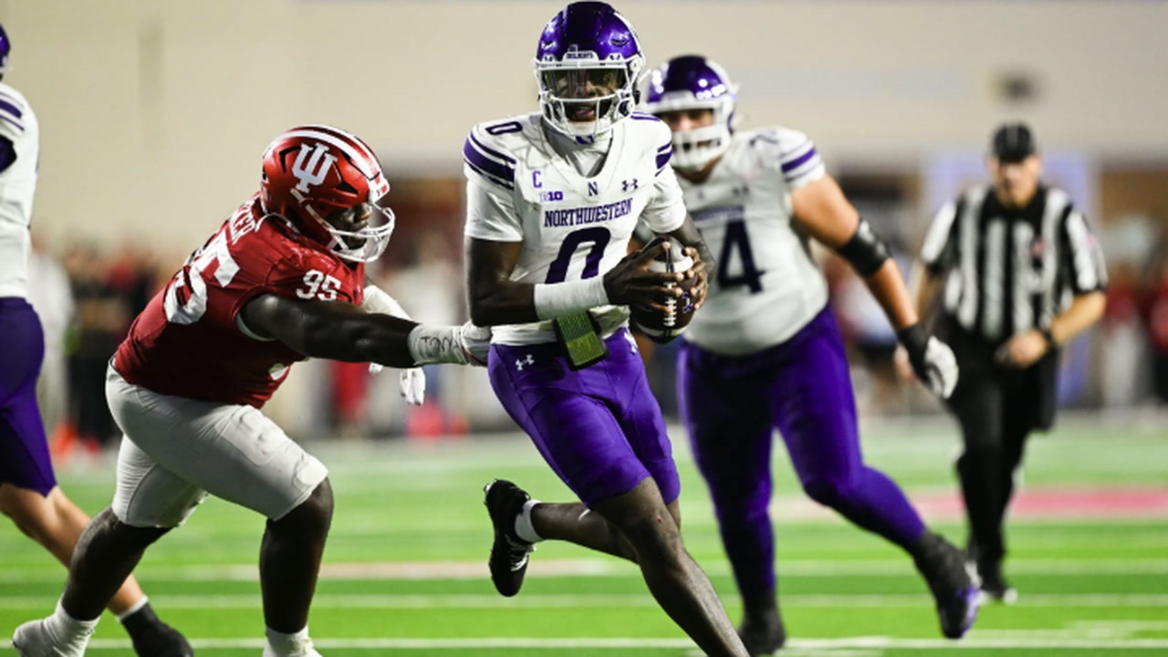 Northwestern number 0 runs with the ball past an Indiana defender