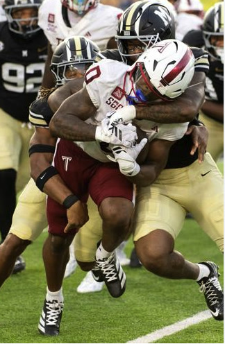 Troy running back Gavin Griffin carries the ball through a pile of tacklers