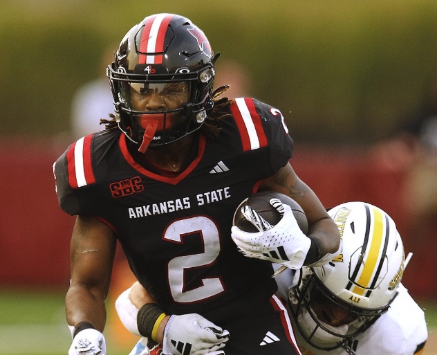 Arkansas State number 2 carries the ball through a tackle