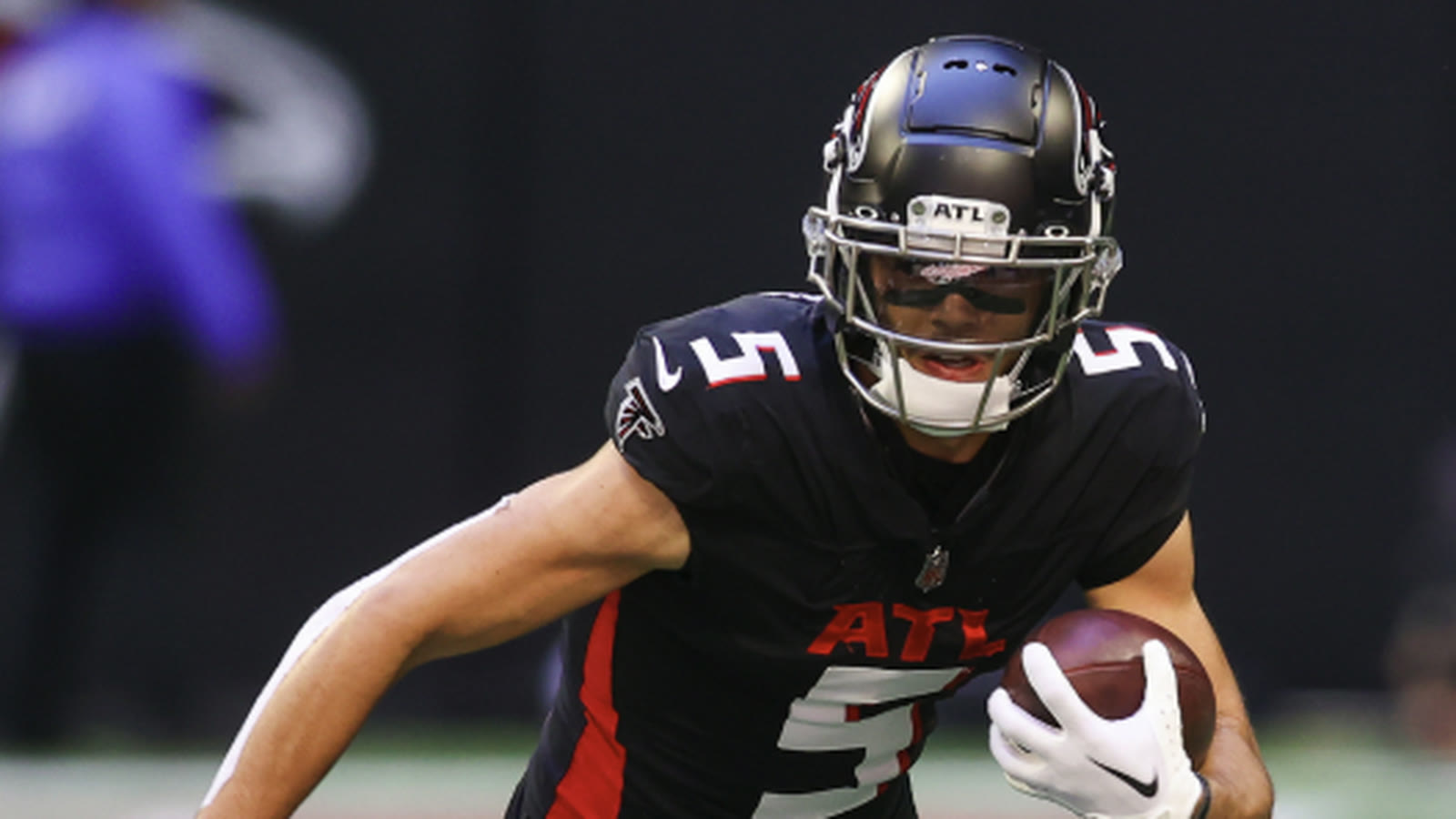 Drake London running with the ball in the Falcons black uniform